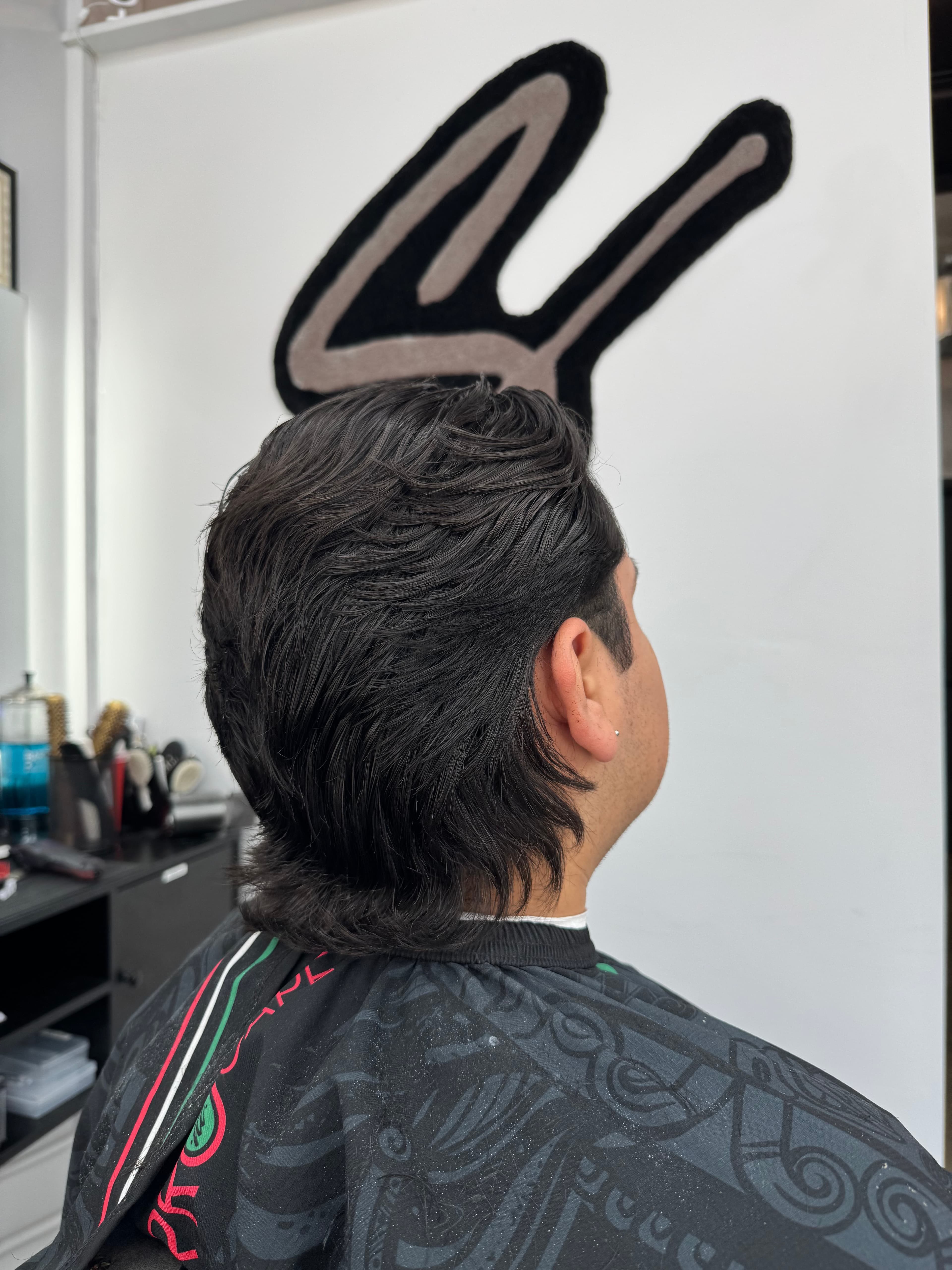 Back and side view of layered, swept-back hair with length at the neckline.